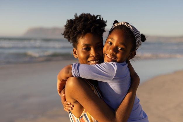 portrait-jeune-femme-afro-americaine-souriante-aux-cheveux-courts-embrassant-sa-fille-contre-mer_13339-309443